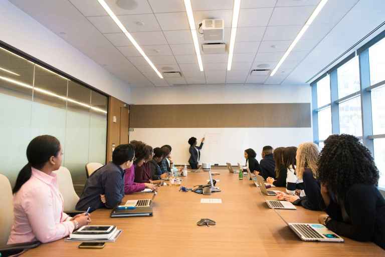 Employees at conference table discussing business ethics and corporate social responsibility